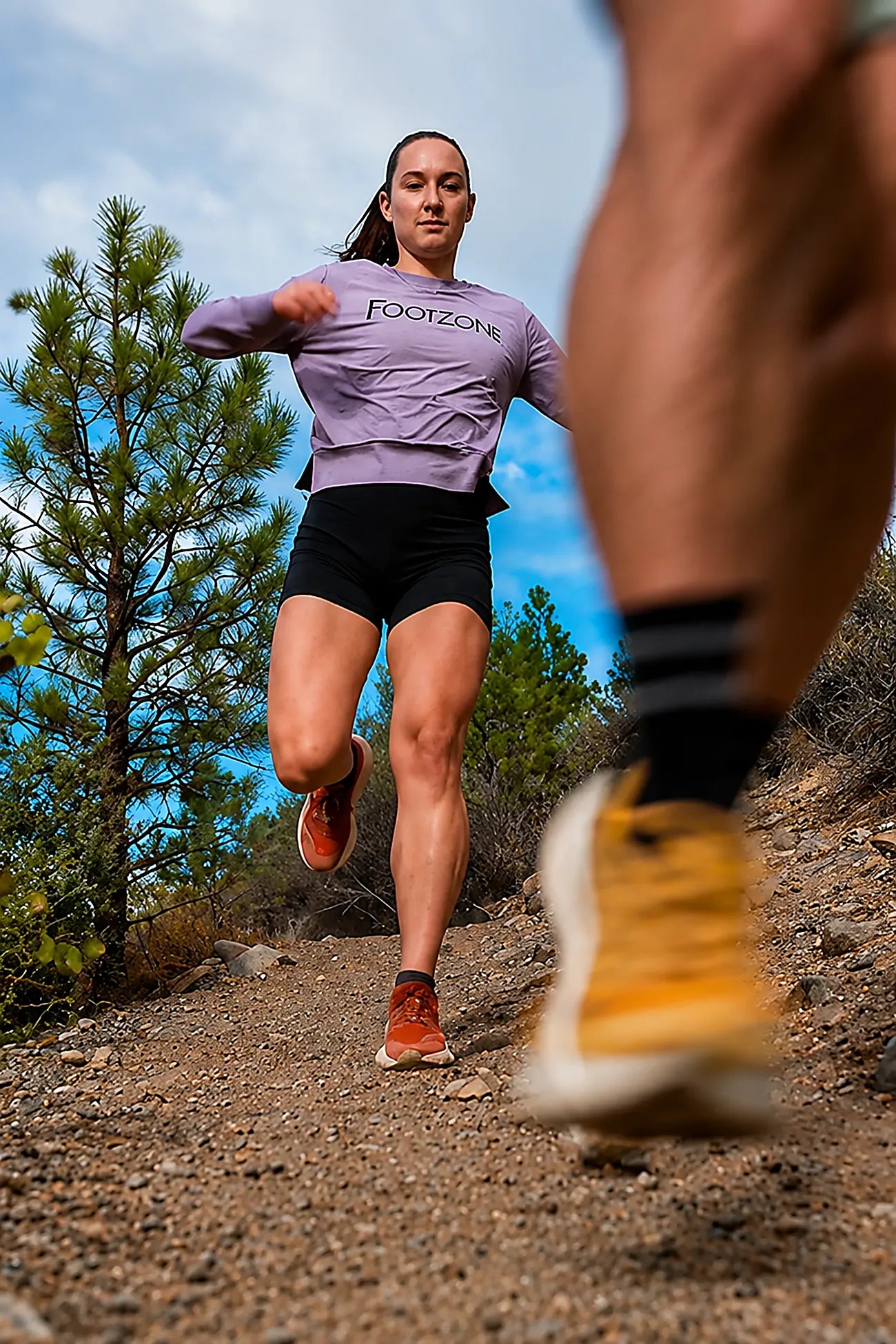Two trail runners on a forest path