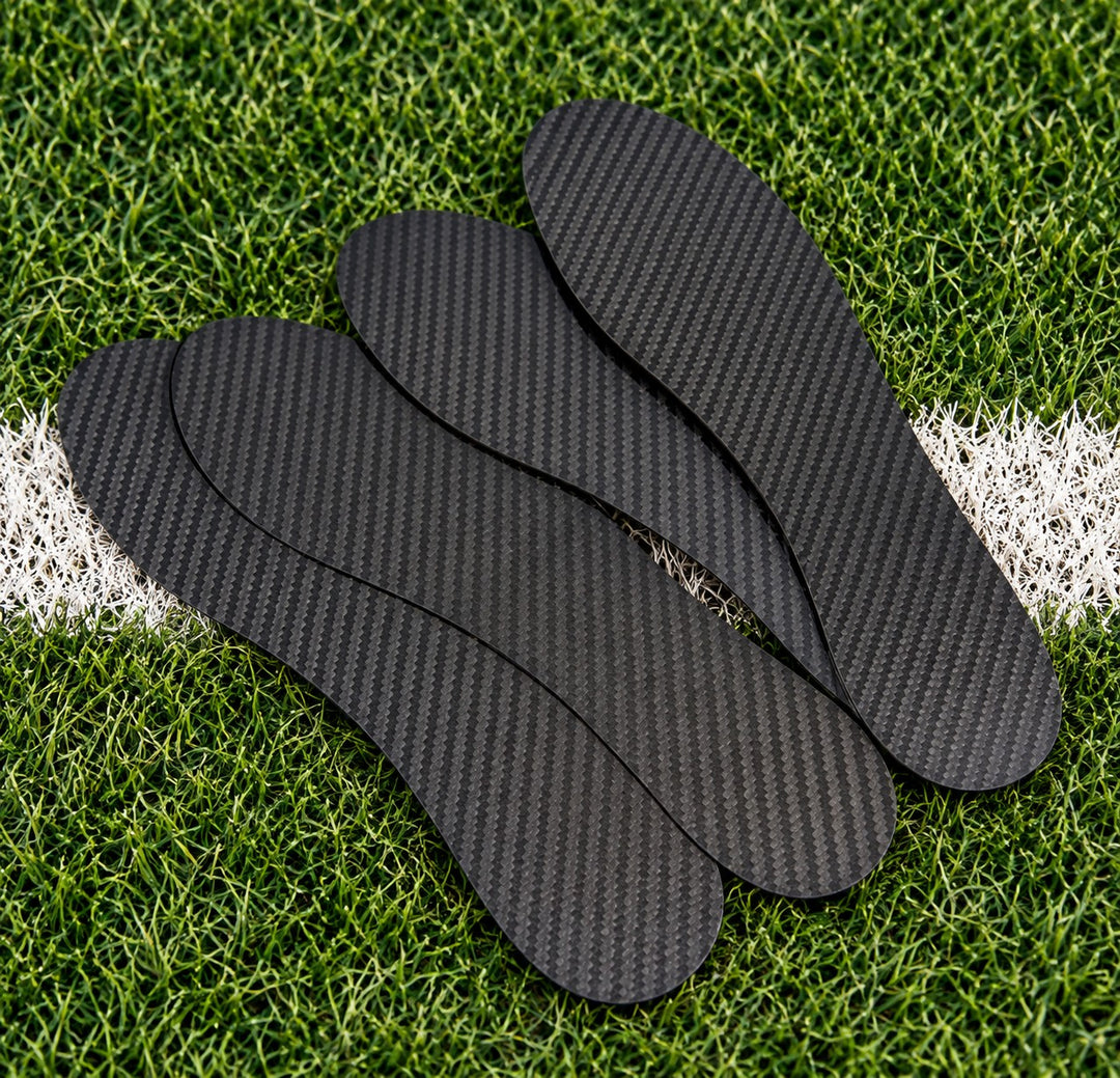 Three Carbon Pro Rigid carbon plates fanned out on turf beside a painted yard line
