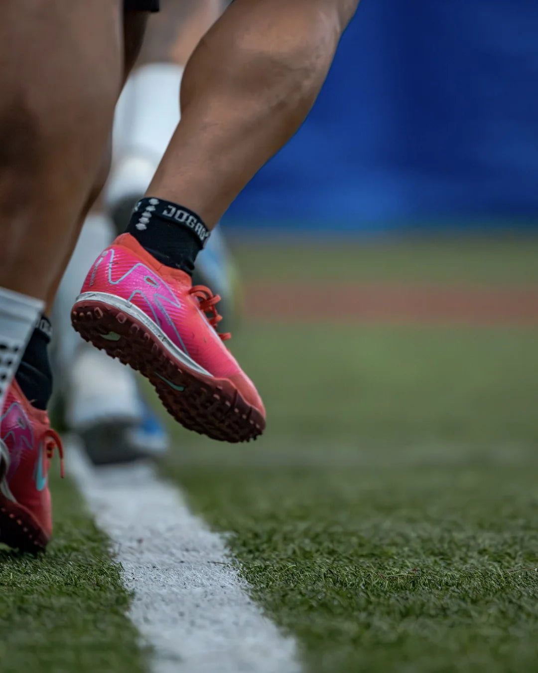 Soccer cleats and socks planting on the turf line