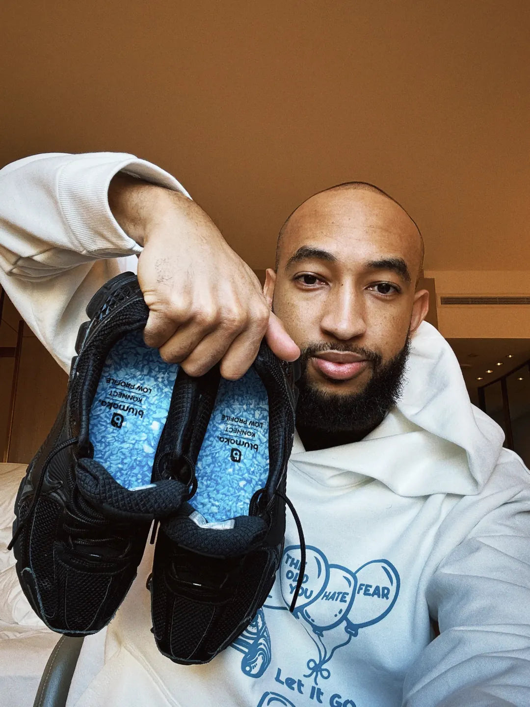 Jordan McLaughlin holding basketball shoes fitted with Blumaka NonSlip insoles