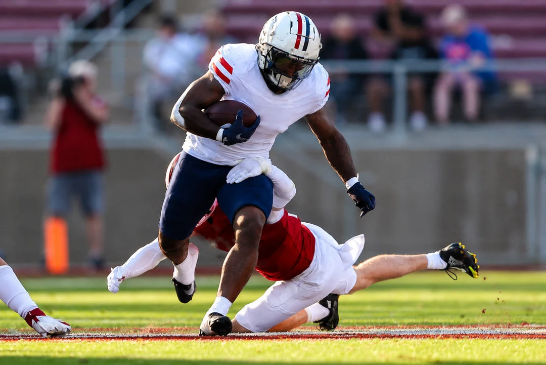 Jonah Coleman breaking a tackle on the field