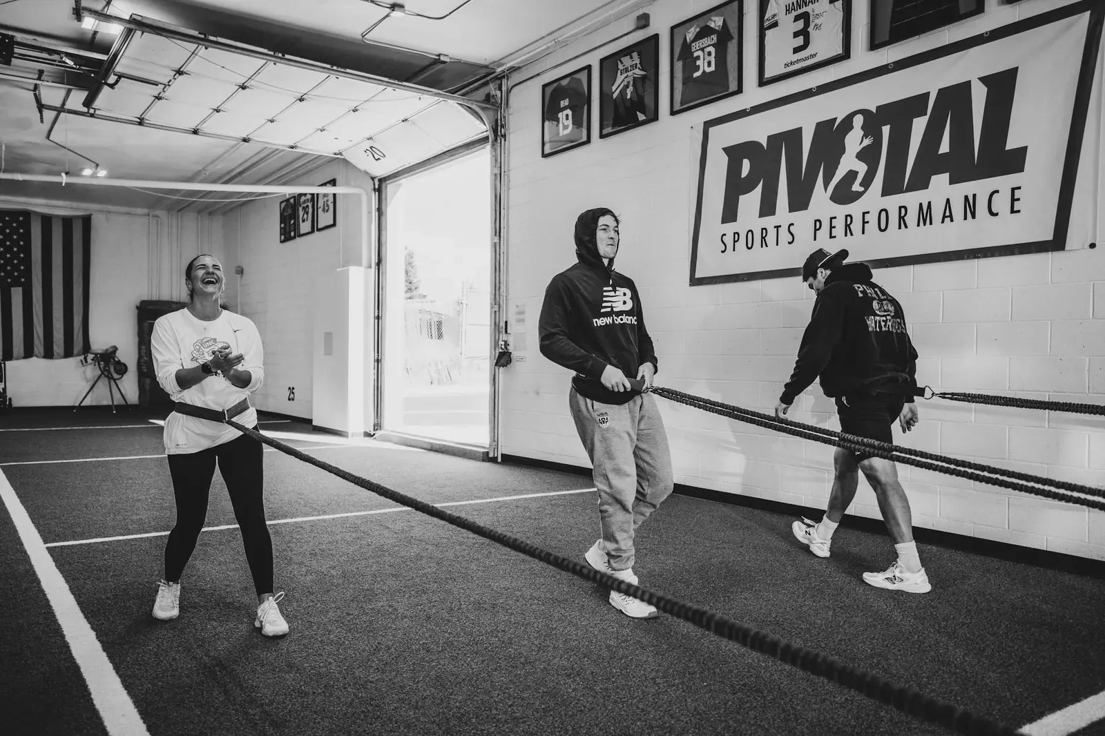 Athletes working through resisted band sprints on the turf during a training session