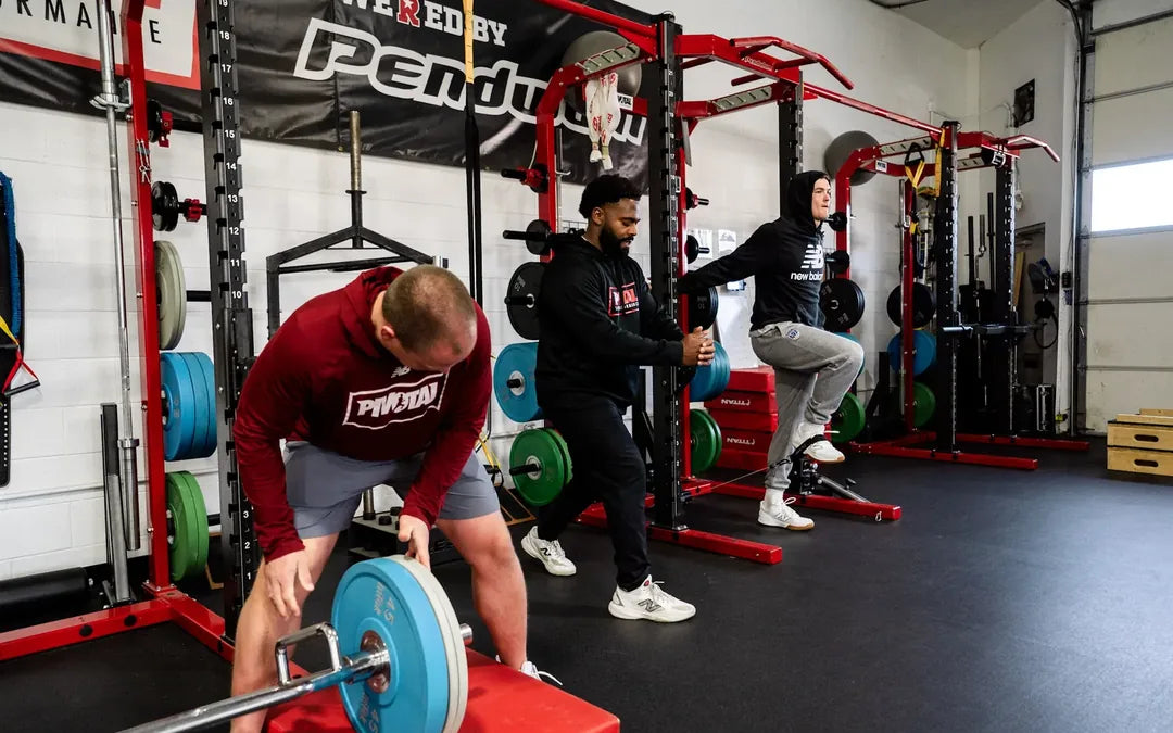 Athletes lifting and working through split squats in the weight room