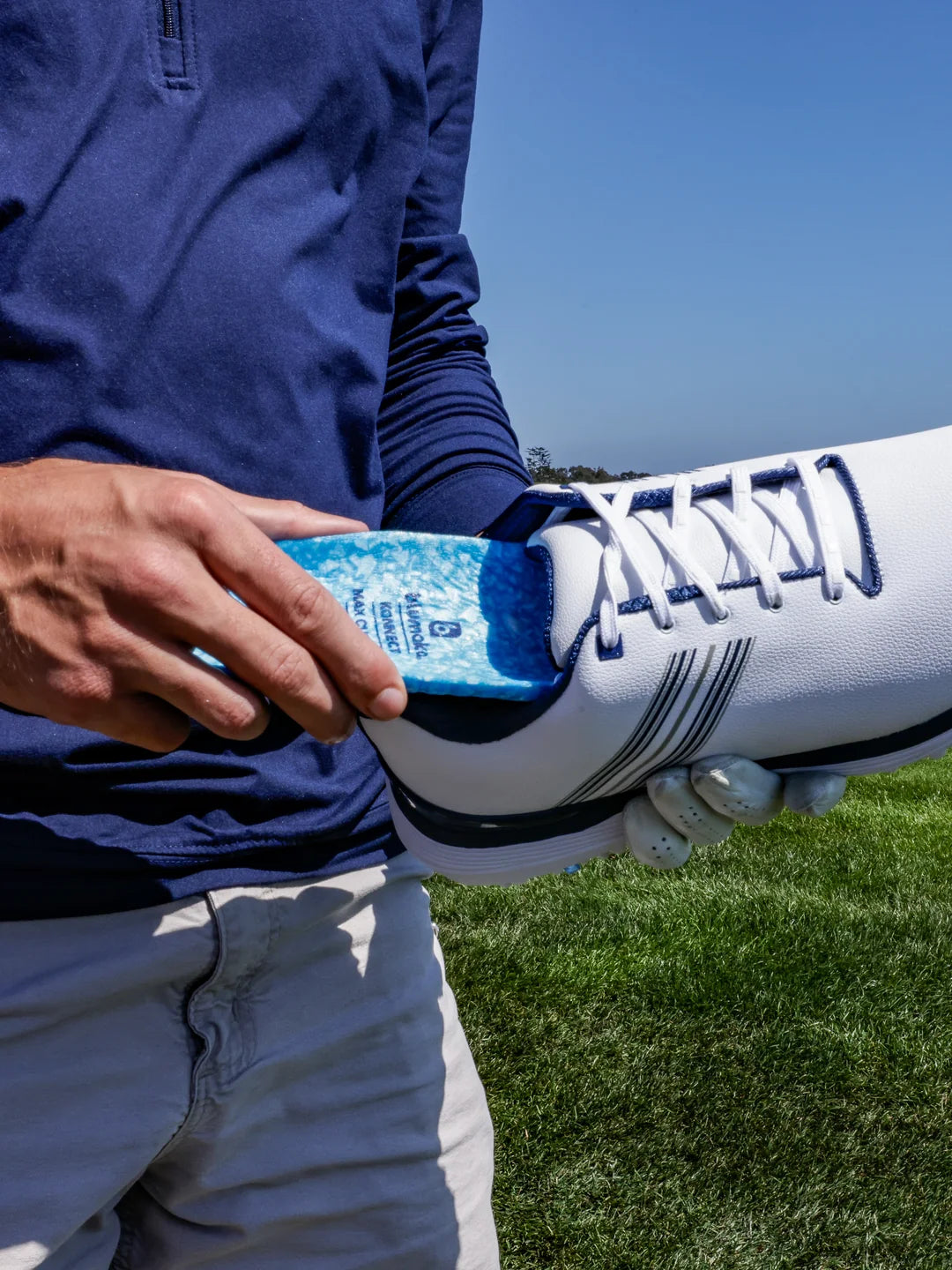 Sliding a Blumaka NonSlip insole into a golf shoe on the course