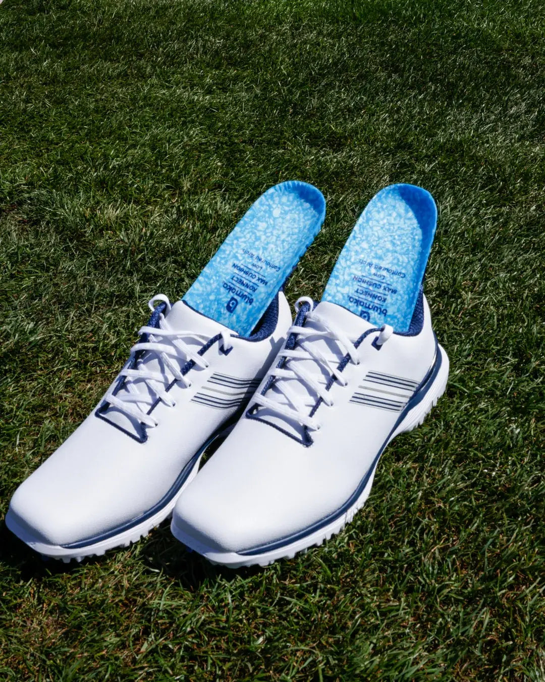 White golf shoes fitted with Blumaka NonSlip insoles on the grass