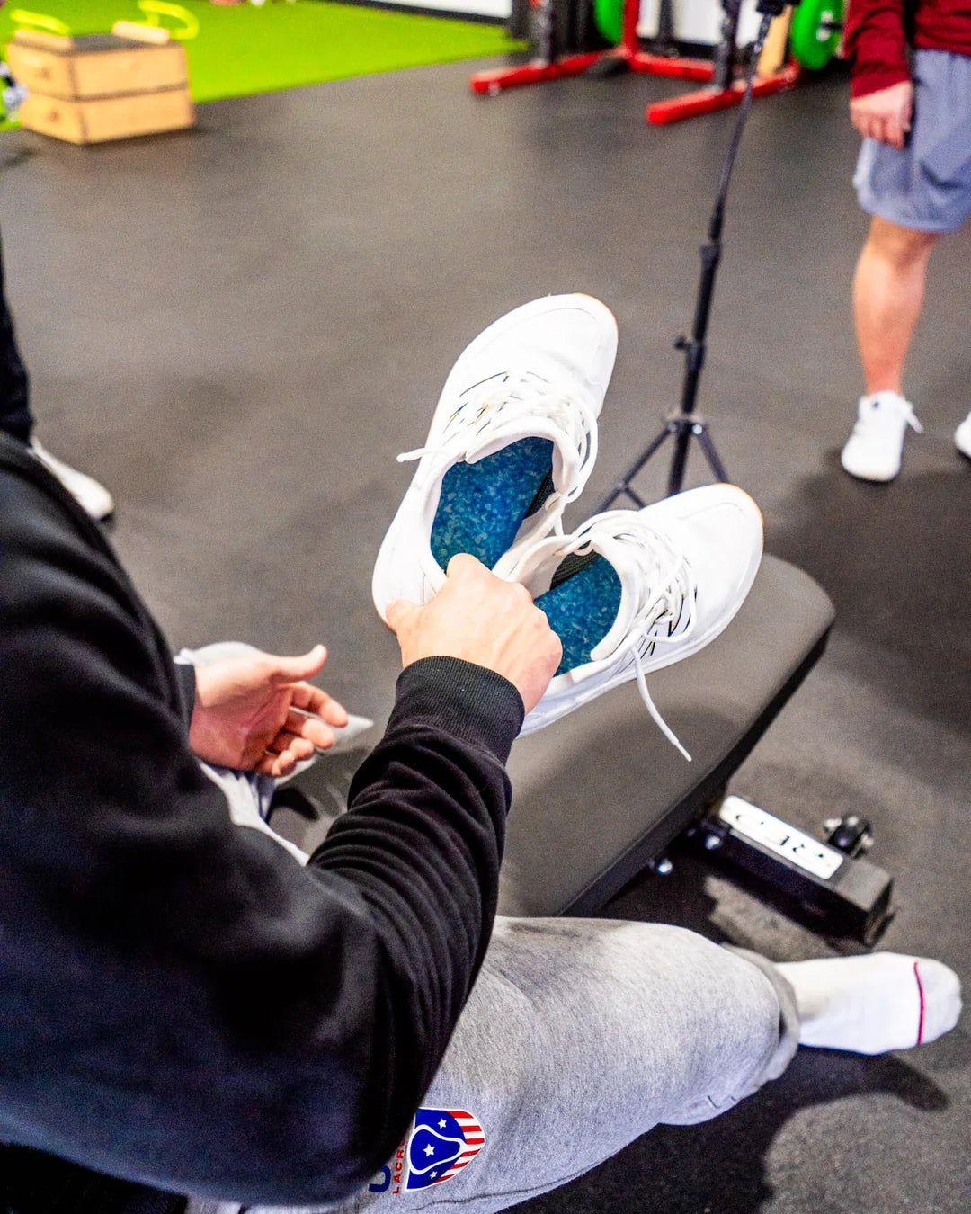 Hands dropping a Blumaka NonSlip insole into a lacrosse cleat
