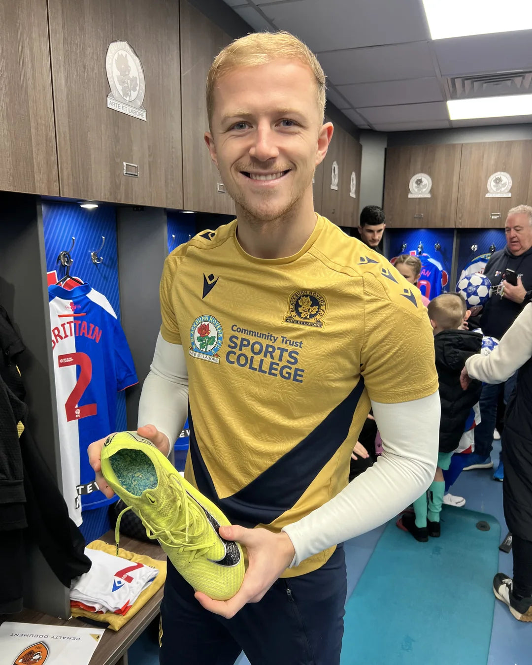 Aynsley Pears holding a soccer cleat in the locker room
